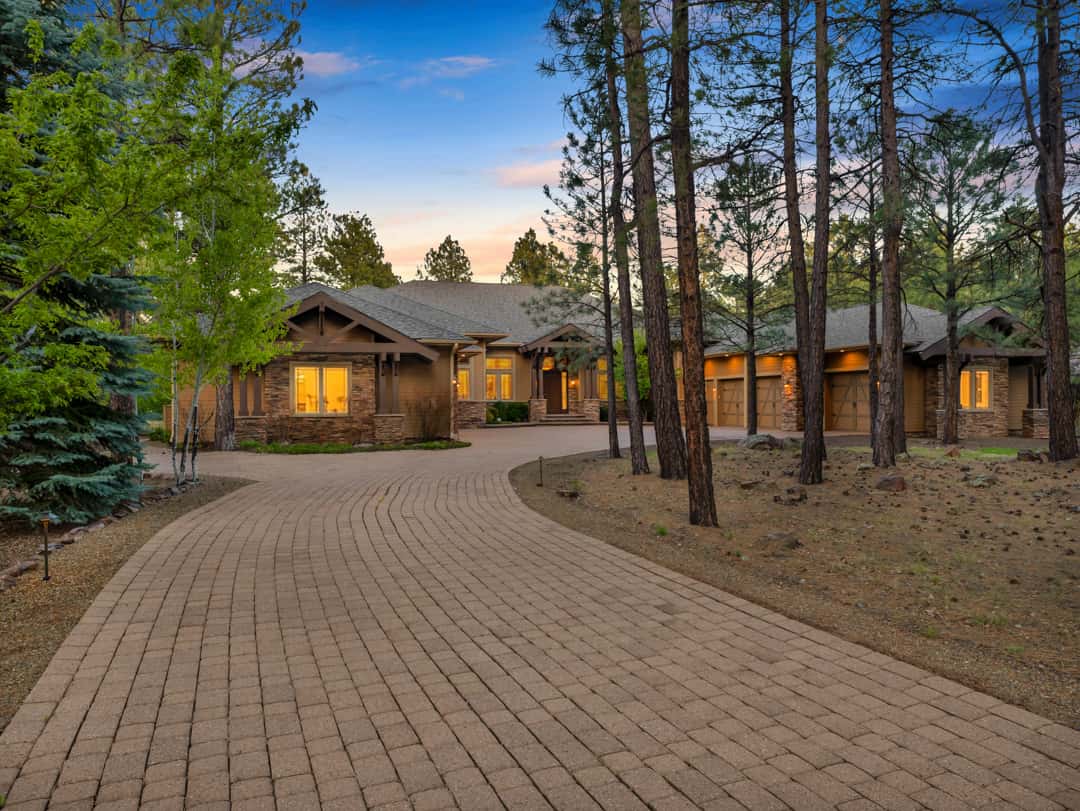 2 of 52. Elegant mountain retreat with a welcoming front entry, mature pine setting, stone detailing, and timeless curb appeal in the prestigious Forest Highlands community.