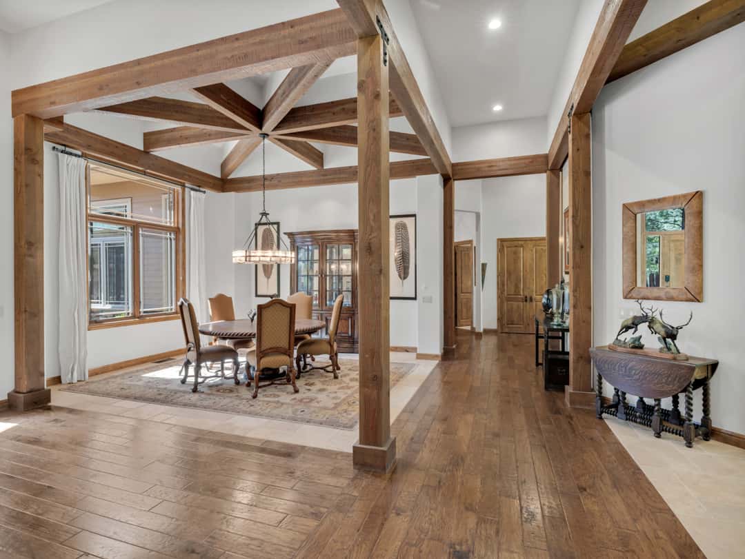 7 of 52. Elegant dining space featuring dramatic timber beams, upscale finishes, natural light, and a warm mountain-modern atmosphere ideal for hosting gatherings.