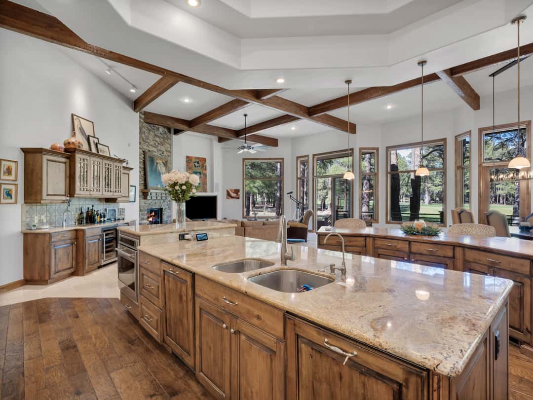 10 of 52. Gourmet kitchen with custom cabinetry, oversized islands, expansive windows, and seamless flow into the great room with beautiful golf course and forest views.