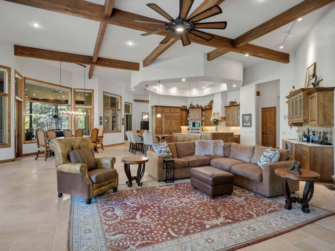 13 of 52. Spacious great room with dramatic timber beams, soaring ceilings, oversized fan, and warm mountain-inspired finishes ideal for entertaining guests and relaxing.