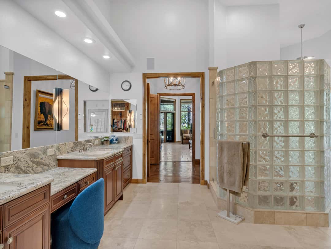20 of 52. Spacious primary bath with glass block shower, premium stone details, dual vanity setup, and refined finishes designed for everyday comfort and luxury living.
