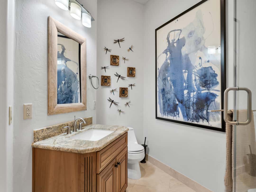 29 of 52. Sophisticated guest bathroom with walk-in glass shower, granite vanity top, custom wood cabinetry, and modern finishes throughout the luxury home.