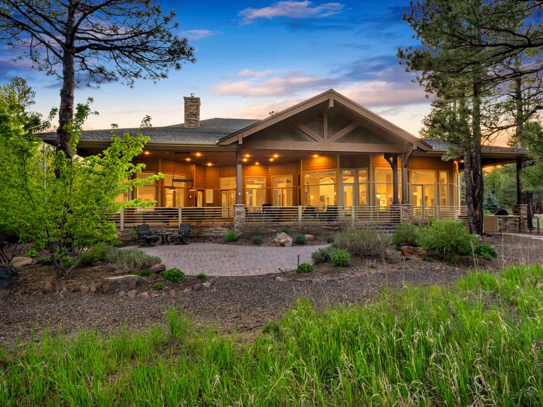 32 of 52. Spectacular rear exterior with expansive covered entertaining areas, custom architectural details, and lush landscaping nestled among towering pine trees.