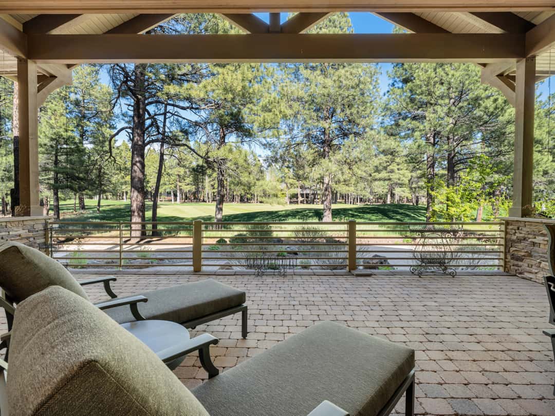 36 of 52. Expansive covered patio overlooking scenic golf course greens and pine trees, offering incredible outdoor relaxation and entertaining opportunities.