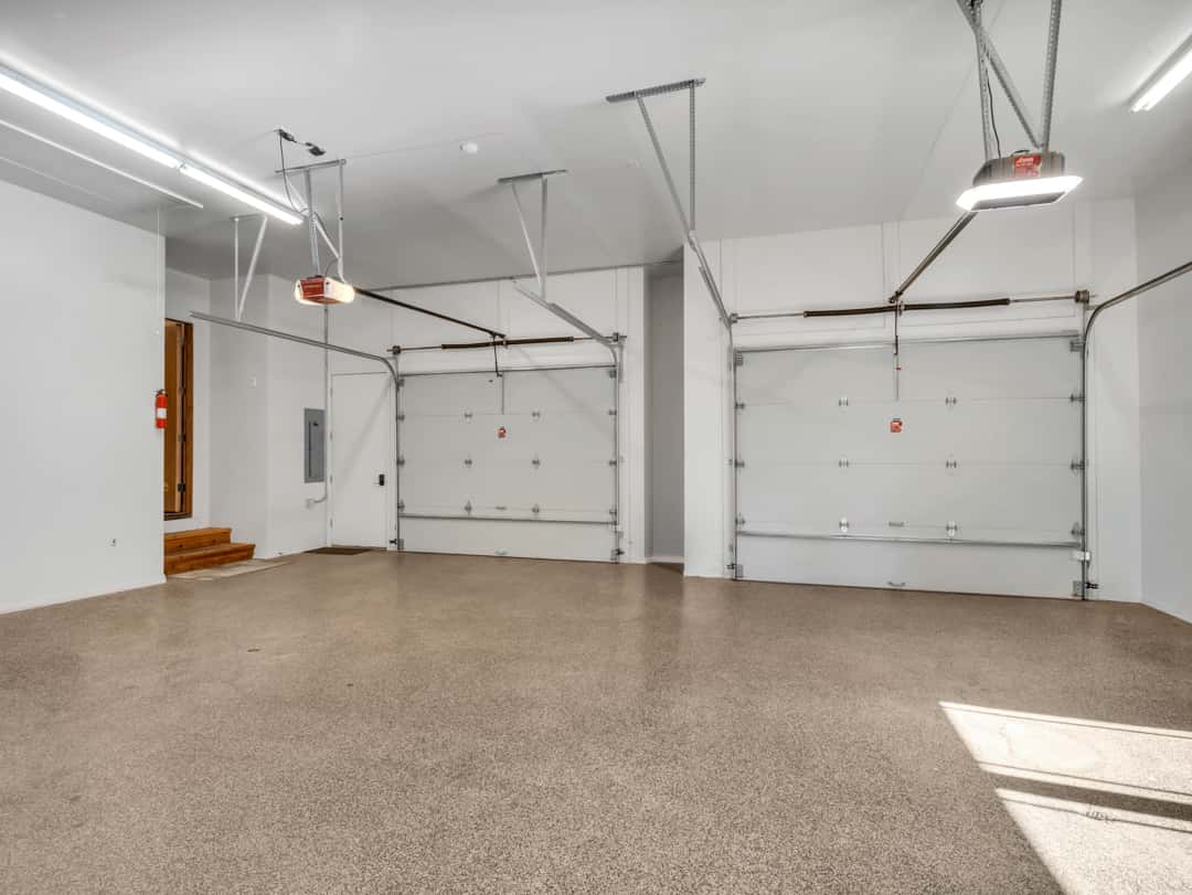44 of 52. Expansive five-car garage with clean finishes, oversized parking areas, and durable epoxy floors perfect for vehicles and storage needs.
