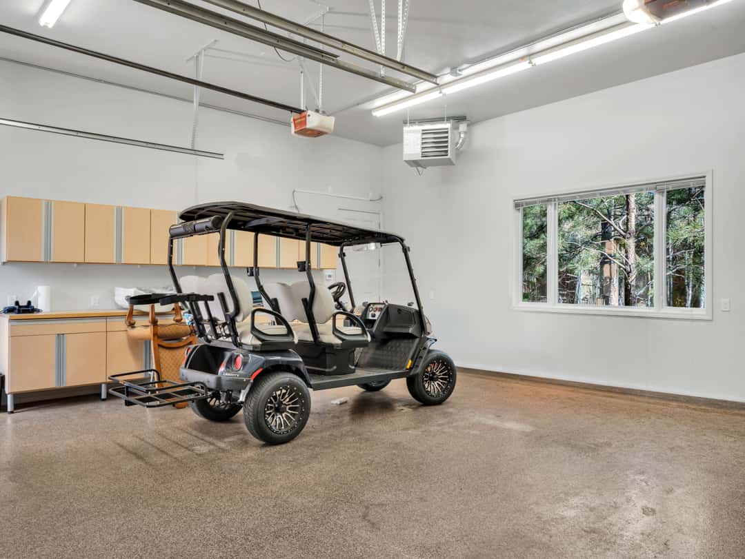 45 of 52. Well-appointed garage featuring built-in storage cabinets, epoxy-coated flooring, heating system, and dedicated golf cart parking space.