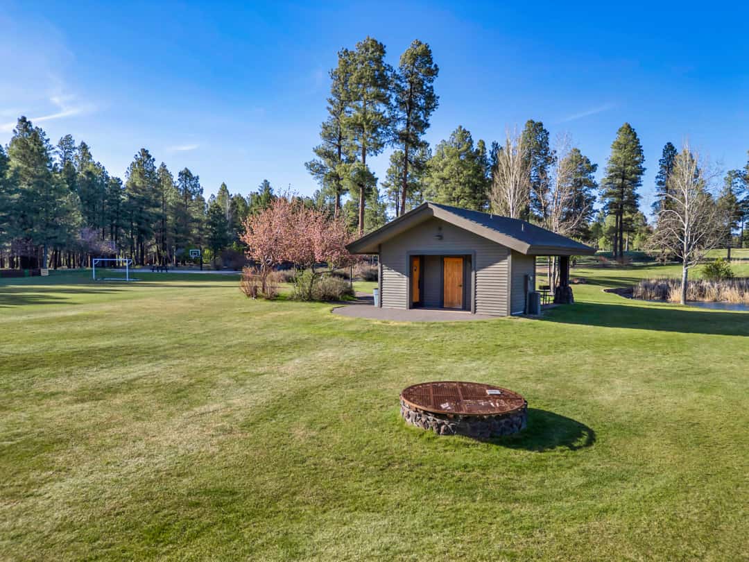 50 of 52. Spacious community park area with lush lawns, recreational amenities, and peaceful forest surroundings just moments from the property.
