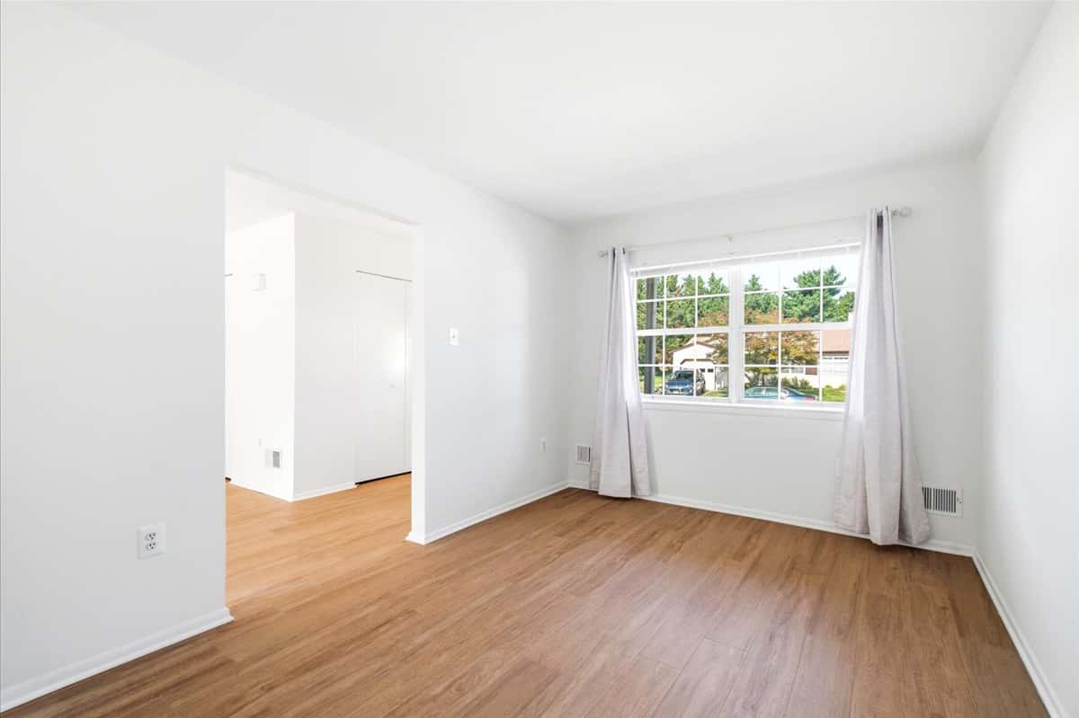 11 of 39. Spacious living area with natural light, featuring easy-maintenance flooring and fresh, neutral wall tones.