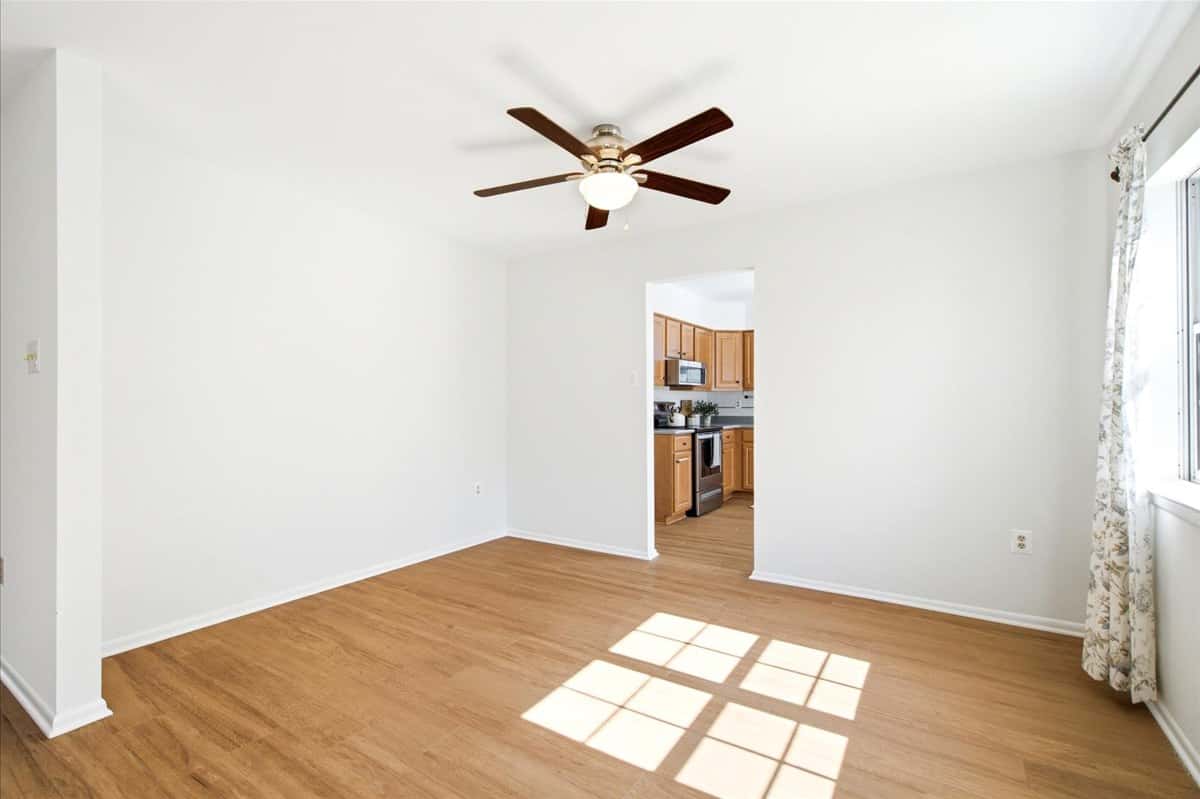 13 of 39. Bright and open living space featuring a ceiling fan and easy access to a modern kitchen.