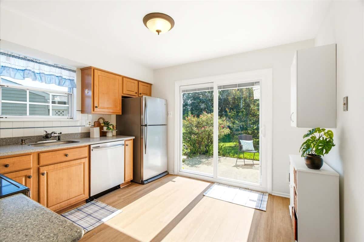 5 of 39. Bright kitchen featuring modern appliances, ample cabinetry, and direct access to a private outdoor space.
