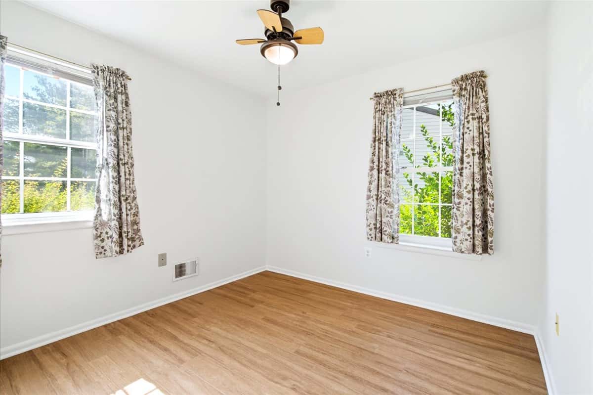 22 of 39. Bright and inviting bedroom with abundant natural light and a ceiling fan for comfort.