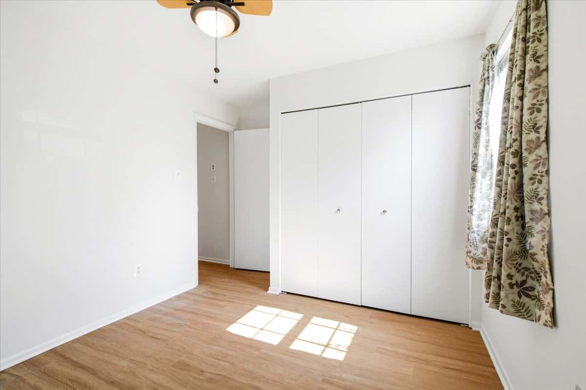 24 of 39. Light-filled room featuring ample closet space and a ceiling fan, ideal for cozy living or working.