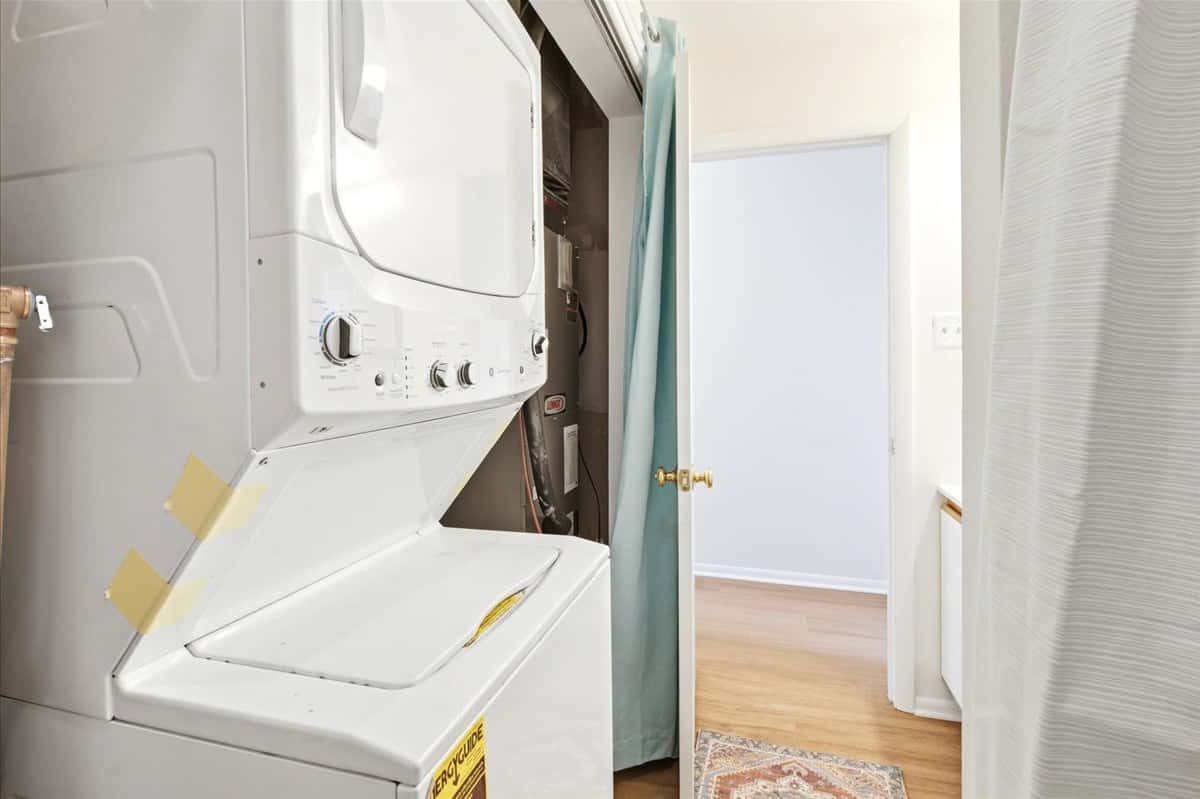 26 of 39. Convenient laundry area with stacked washer and dryer, adjacent to accessible living spaces for efficiency.