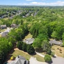Stunning aerial view showcasing a lush, green neighborhood with spacious homes and tree-lined streets.