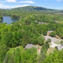 Expansive property featuring lush greenery, scenic views, and proximity to a tranquil lake for outdoor enjoyment.