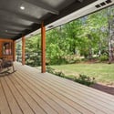 Relax on the spacious porch overlooking a lush landscape, perfect for enjoying nature's beauty.