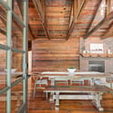 Spacious open-concept living area features rustic wood beams, inviting dining space, and a cozy fireplace.