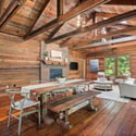 Bright, open space featuring natural wood beams, a cozy fireplace, and inviting dining area for gatherings.