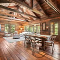 Spacious open-concept living area featuring natural wood finishes and abundant light through large windows.