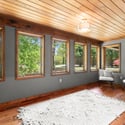 Bright and airy sunroom featuring expansive windows and natural wood accents, perfect for relaxation or cozy gatherings.