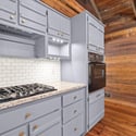This modern kitchen features sleek cabinetry, a gas range, and rustic wood accents for a unique touch.
