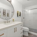 Modern bathroom featuring a spacious shower, dual sinks, and natural light from well-placed windows.