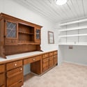 Spacious work area featuring built-in cabinetry and shelving, ideal for crafting or organization.