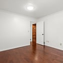 Bright, versatile room with hardwood flooring and direct access to adjoining spaces, perfect for various uses.