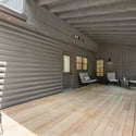 Spacious covered deck features wood flooring, perfect for outdoor gatherings and relaxation in any weather.