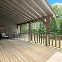 Relax on the expansive covered deck, surrounded by lush greenery and serene natural views.
