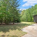 Spacious outdoor area surrounded by lush greenery, perfect for relaxation or entertaining family and friends.