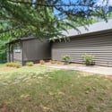 This unique log cabin features a spacious yard and a blend of natural surroundings and modern living.
