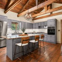 Modern kitchen featuring a spacious island, high ceilings, and rich wooden accents for a warm atmosphere.