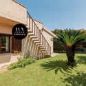 Discover a spacious villa featuring a lovely garden and inviting staircase, perfect for outdoor living.