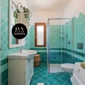 Bright bathroom featuring bold turquoise tiles, modern fixtures, and thoughtful storage options throughout.