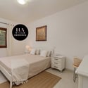 Bright and inviting bedroom featuring large windows, minimalist decor, and ample natural light throughout.