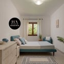 Bright and welcoming bedroom featuring natural light, modern furnishings, and a tranquil view of greenery.