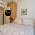 This cozy bedroom features a light color scheme and convenient storage, perfect for comfort and relaxation.