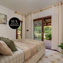 Bright bedroom with outdoor access, featuring plush bedding and inviting greenery for a refreshing ambiance.