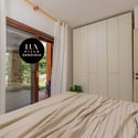 Cozy bedroom featuring ample storage and direct access to a lush outdoor patio area.