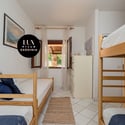 Bright and airy room featuring bunk beds, natural light, and views of the surrounding greenery.