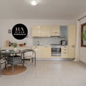 Modern kitchen with a cozy dining area, featuring sleek cabinetry and natural light. Perfect for entertaining.