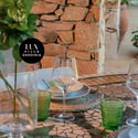 Discover a unique outdoor dining space, featuring mosaic tables and a lush, vibrant garden backdrop.