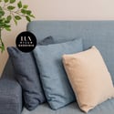 Cozy, inviting space featuring a comfortable sofa adorned with textured cushions and greenery for warmth.