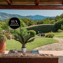 Experience breathtaking coastal views from this inviting outdoor living space surrounded by lush greenery.