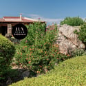 Discover a unique villa in Sardinia, surrounded by vibrant gardens and stunning natural rock formations.