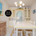 Bright and inviting dining area featuring ample natural light and a cozy kitchen space, perfect for gatherings.