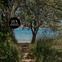 Discover a tranquil pathway leading to stunning waterfront views in this exclusive Sardinia villa setting.