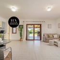 Spacious open-plan living area seamlessly connects to a sunlit patio with captivating garden views.