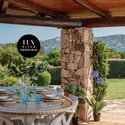 Experience outdoor dining with stunning views of the lush landscape and coastline in this inviting villa.